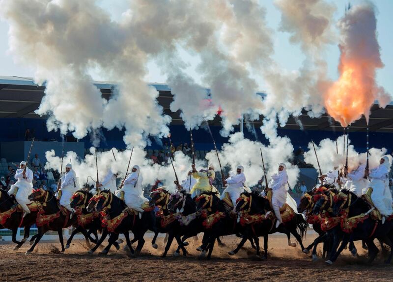 A troupe charges and fire their rifles loaded with gunpowder during a national competition for Tabourida, salon du cheval d'el jadida, in El Jadida, Morocco.  EPA