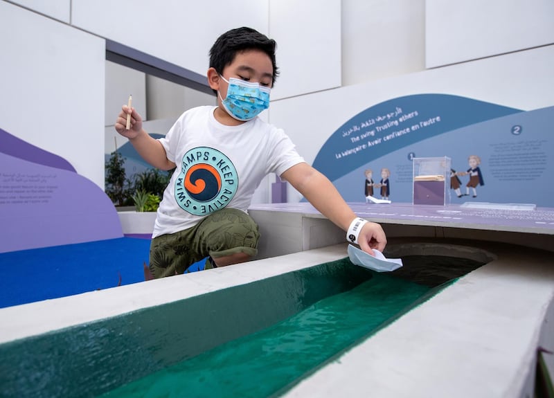 Louvre Abu Dhabi Children’s Museum reopens this week. Preview/tour of the revamped space June, 15, 2021. Jacob Morella, 4, launches his paper boat at the garden area of the exhibition. Victor Besa / The National. 
Reporter: Alexandra Chaves for Arts & Culture.