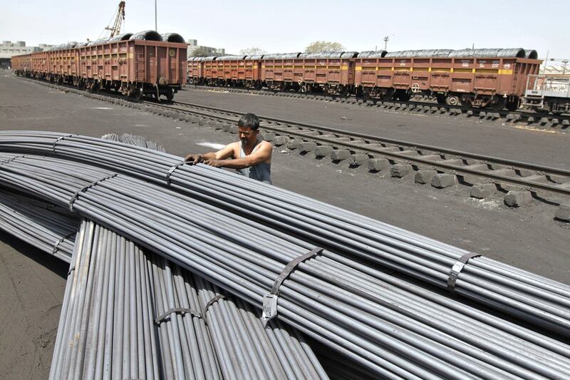 A worker unties a stack of iron pipes after they are unloaded from a train wagon at a yard in Ahmedabad. Indian Railwaus carried 866.14 million tonnes of revenue-earning freight traffic from April last year to January. Amit Dave / Reuters