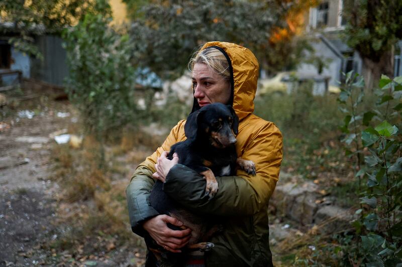 A woman carries a dog at a site of a residential building heavily damaged by a Russian missile strike in Mykolaiv, Ukraine. Reuters