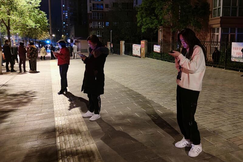 People wait outside in Xining, capital of western China's Qinghai province, following a 7.3 magnitude earthquake in Maduo county. Geophysicists said it was not related to the earlier Yunnan earthquake. AP Photo