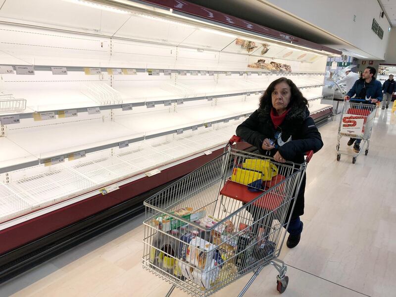Empty shelves at a supermarket as people stockpile due to the fear of the coronavirus, in Pioltello near Milan, Italy.  EPA