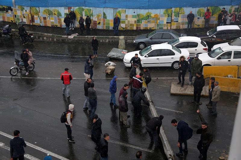 Protesters block a road in Tehran after the government raised petrol prices.  AP