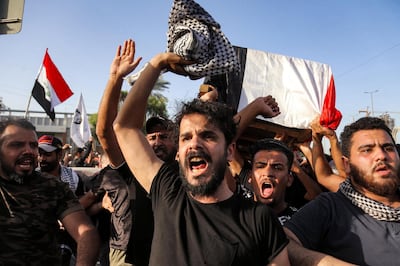 People chant slogans as they march with the body of renowned Iraqi anti-government activist Ihab al-Wazni (Ehab al-Ouazni) during a funerary procession in the central holy shrine city of Karbala on May 9, 2021 following his assassination. - Wazni, a coordinator of protests in the Shiite shrine city of Karbala, was a vocal opponent of corruption, the stranglehold of Tehran-linked armed groups and Iran's influence in Iraq. He was shot overnight outside his home by men on motorbikes, in an ambush caught on surveillance cameras. He had narrowly escaped death in December 2019, when men on motorbikes used silenced weapons to kill fellow activist Fahem al-Tai as he was dropping him home in Karbala, where pro-Tehran armed groups are legion. (Photo by Mohammed SAWAF / AFP)
