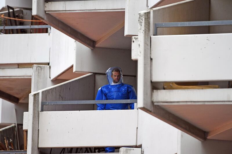 FILE - In this June 15, 2018 file photo a German police officer in protective gear walks down stairs in an apartment building at Osloerstrasse 3, in Cologne, Germany. Federal prosecutors say they have filed charges against a Tunisian suspect and his German wife who are accused of producing biological weapons for an attack in Germany. (Henning Kaiser/dpa via AP)