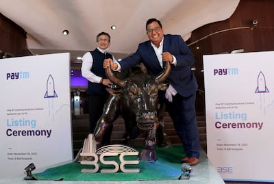 Paytm founder and chief executive Vijay Sharma poses with a bronze replica of a bull as Ashishkumar Chauhan, managing director and chief executive of Bombay Stock Exchange looks on after the company's IPO listing ceremony in Mumbai. Reuters