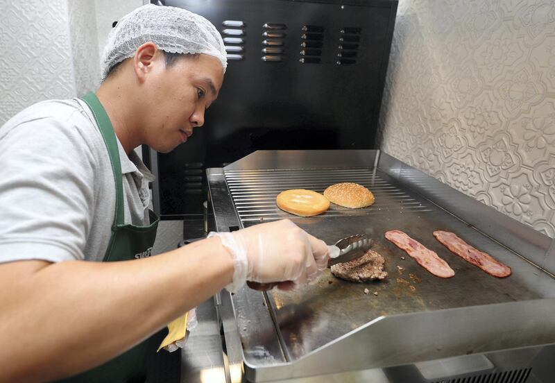 Abu Dhabi, United Arab Emirates - September 15, 2019: Chef Edmar creates the IT burger. A look at the newly opened Sweet Greens café. They have a special focus on being healthy and environmentally friendly. Sunday the 15th of September 2019. Rihan Heights, Abu Dhabi. Chris Whiteoak / The National