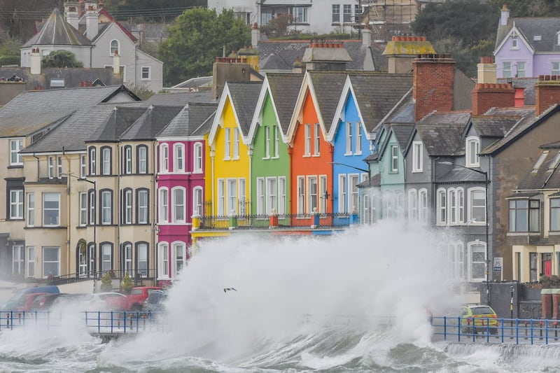 Waves crash on to a road in Whitehead, Northern Ireland. PA