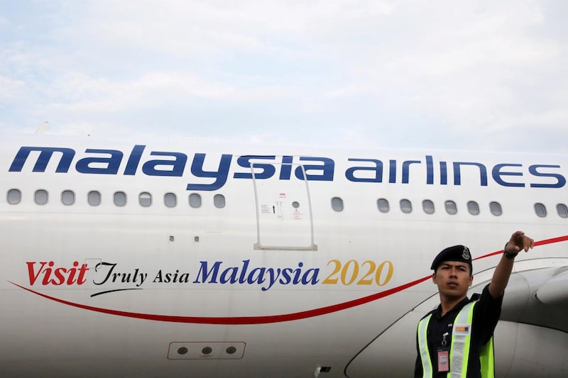 An airport employee beside a Malaysia Airlines plane at Kuala Lumpur International Airport in Sepang, Malaysia, July 22, 2019. REUTERS/Lim Huey Teng