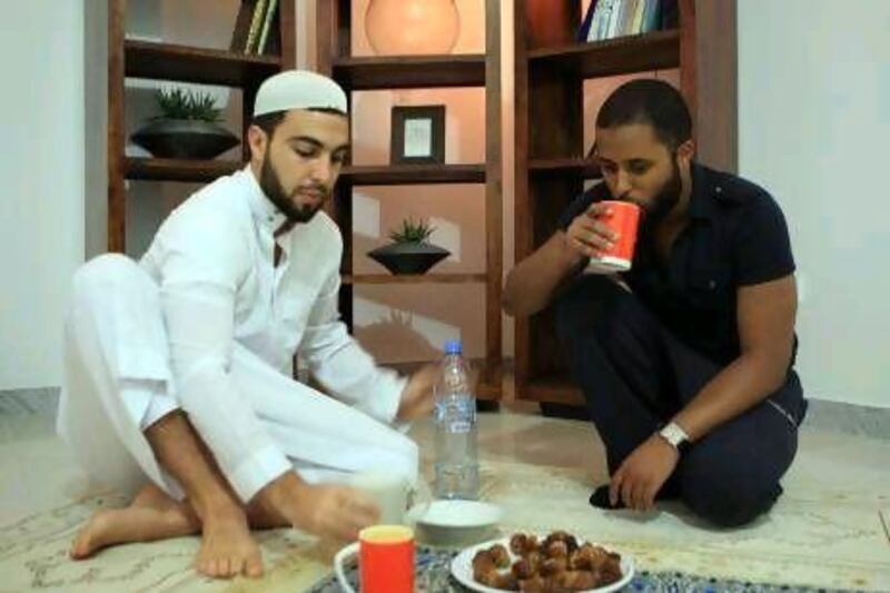 Mehdi Popotte, right, with his friend Mohamed Walid, break their fast at their residence during the holy month ramadan in Abu Dhabi.