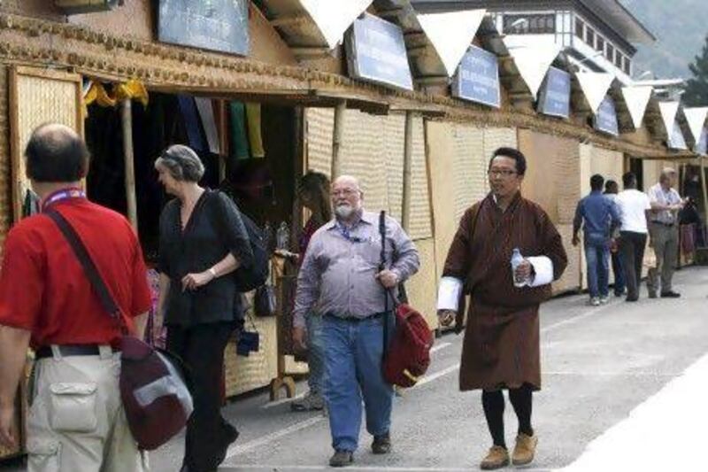 A tourist group walk past a row of shops selling handicrafts with a local guide in Thimphu. Premium-paying tourists have long eulogised Bhutan's unspoilt charms, its peace and its pristine environment, but the Himalayan kingdom, famed as the "last Shangri-La", and for using happiness to measure its success, is no idyll.