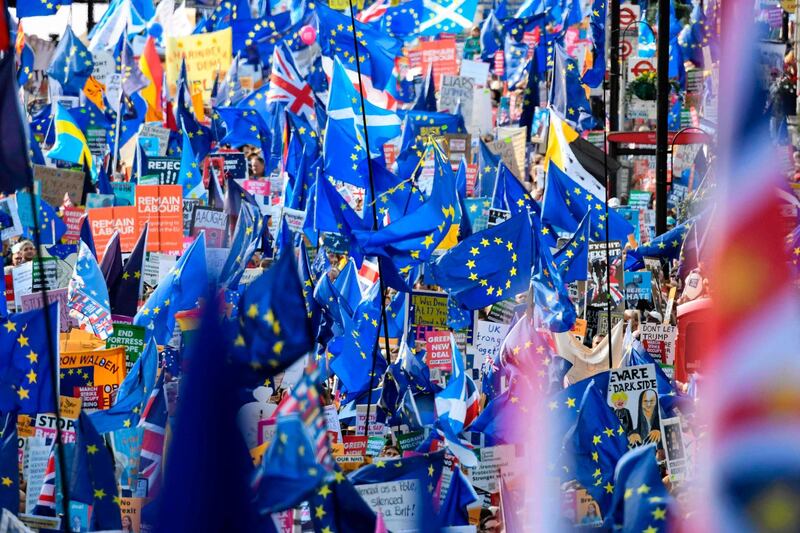 Demonstrators hold placards and EU and Union flags as they take part in a march by the People's Vote organisation in central London. AFP