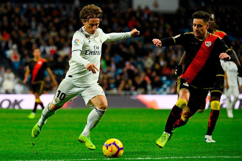 Real Madrid Luka Modric (L) vies with Rayo Vallecano defender Alex Moreno. AFP