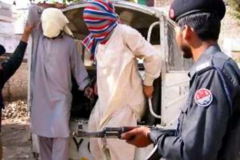 Policemen take unidentified alleged activists of extremist Islamic parties Sipah-e-Sahaba and Jaish-e-Mohammed to a Central Investigation Centre, Multan, on Saturday May 11, 2002. In an operation against the banned extremist Islamic parties, several alleged activists have been arrested in different regions of Pakistan's eastern Punjab province. (AP Photo/Khalid Tanveer)