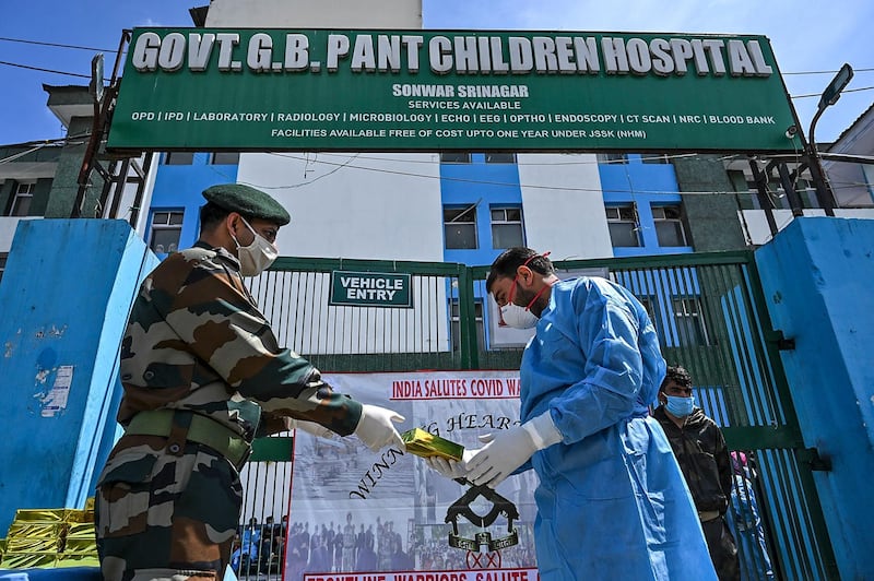 An army officer hands out gifts to medical staff at a children's hospital in Srinagar. AFP