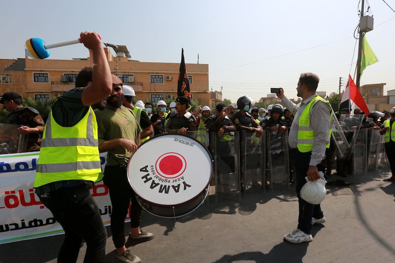 The demo takes place to the beat of a drum as riot police take up positions nearby. EPA