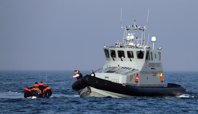 A Border Force vessel assist a group of people thought to be migrants on board from their inflatable dinghy in the Channel, Monday Aug. 10, 2020. A Royal Air Force surveillance plane is flying over the English Channel as the British government tries to curb the number of people crossing from France in small boats. Britainâ€™s Conservative government has talked tough amid a surge in the number of migrants crossing the Channel during recent warm summer weather. (Gareth Fuller/PA via AP)