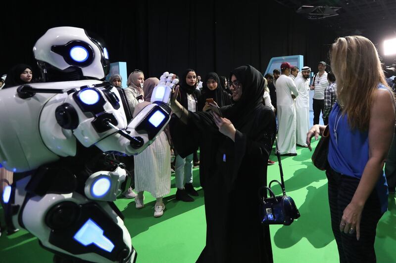 epa07920041 Visitors interact with a robot during Dubai Artificial Intelligence in Sports (DAIS) Conference and Exhibition in Dubai, UAE, 14 October 2019. Reports state the two-day event is bringing together leading figures from the sport and Artificial Intelligence (AI) arenas for discussions on integrating AI into sports industry.  EPA/ALI HAIDER
