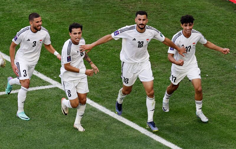 Ayman Hussein celebrates scoring Iraq's second goal with his teammates. Reuters