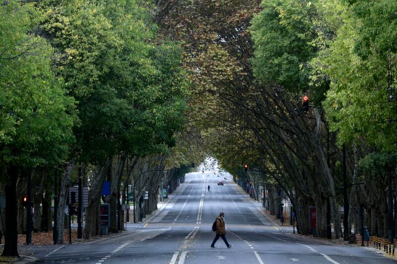 A man walks across Lisbon's main Liberdade Avenue. The Portuguese government has put in place safety measures against the spread of the pandemic. AP Photo