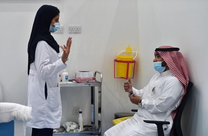 A nurse speaks to a man before administering the Pfizer-BioNTech COVID-19 coronavirus vaccine. AFP