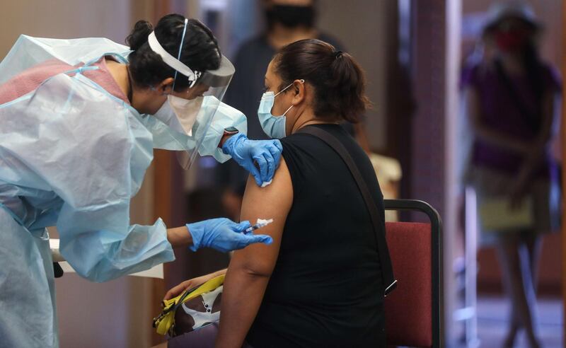 A nurse prepares to administer a flu vaccination shot to a woman at a free clinic held at a local library in Lakewood, California. Medical experts are hoping the flu shot this year will help prevent a ‘twindemic’ - an epidemic of influenza paired with a second wave of Covid-19, which could lead to overwhelmed hospitals amid the coronavirus pandemic.  AFP