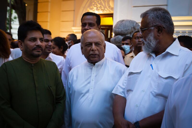 Dinesh Gunawardena, centre, leader of the House of Parliament, arrives at Gangaramaya Temple in Colombo. Getty