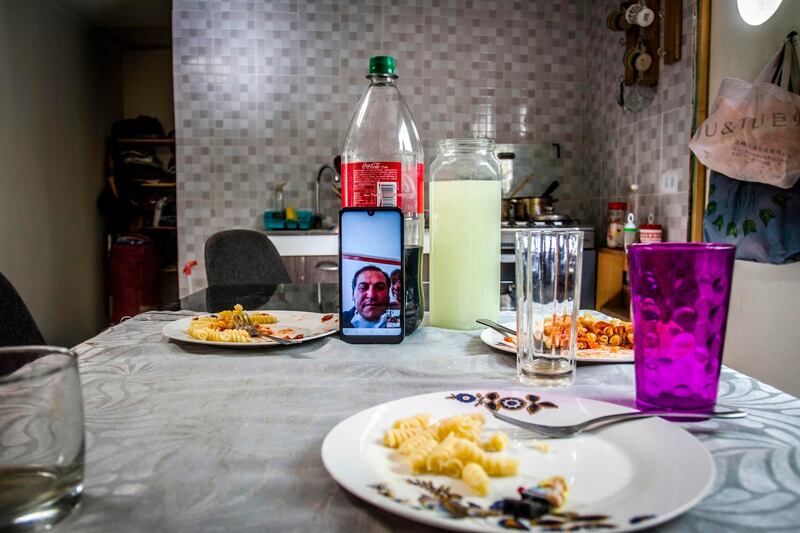 View of a phone on a table as four-year-old twins Fernan and Matilda (out of frame) make a video call to their grandparents during supper at their home in Santiago, Chile on April 16, 2020. AFP