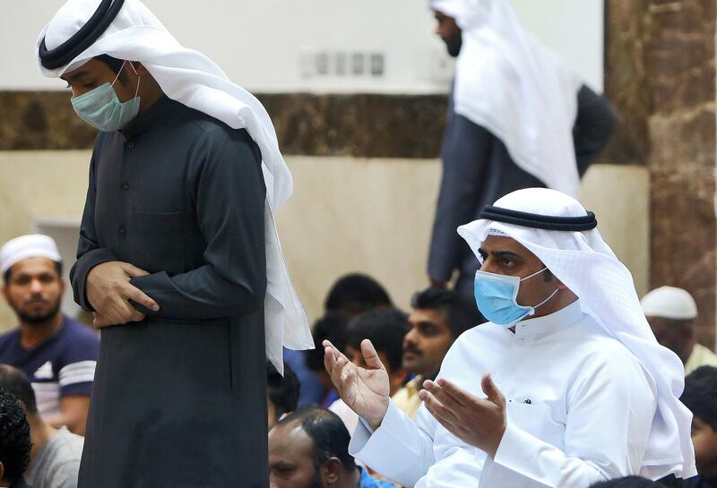 Muslim men wearing protective masks perform Friday prayers at a mosque in Kuwait City on February 28, 2020. - Kuwait's Ministry of Awqaf and Islamic Affairs set the Friday prayer sermon to not exceed 10 minutes, and to discuss precautions against COVID-19 coronavirus disease infections. Kuwait has recorded 43 coronavirus cases since its outbreak, the United Arab Emirates reported 13, while Bahrain has 33, and Oman is at four cases. Government institutions in the gulf country suspended the use of fingerprint recognition to clock in and out. (Photo by YASSER AL-ZAYYAT / AFP)