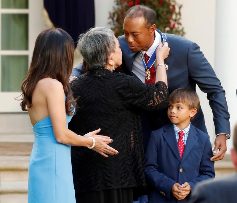 Tiger Woods is embraced by his mother Kultida Woods after being presented with the Presidential Medal of Freedom, as his girlfriend Erica Herman and his 10-year-old son Charlie look on in the Rose Garden at the White House in Washington in 2019. Reuters