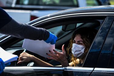 A woman collects unemployment forms at a drive-thru collection point in Florida. Another 6.6 million US workers filed for unemployment benefits for the week ending April 4. Photo: AFP