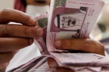 A Saudi banker counts out new 100 riyal notes: the country's banking regulator has launched regulatory sandbox to test financial technologies. AFP