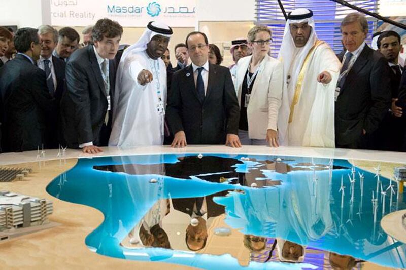 France's President Francois Hollande (C) visits with Sultan Ahmed al-Jaber (2R), chief executive officer of the Abu Dhabi Future Energy Company (MASDAR), French Ecology Minister Delphine Batho (3R), French Minister for Industrial Recovery Arnaud Montebourg (front-L)  during a tour of the company's exhibition at the World Future Energy Summit (WFES) at the Abu Dhabi National Exhibitions Centre (ADNEC) in the Emirati capital on January 15, 2013. AFP PHOTO/BERTRAND LANGOIS


