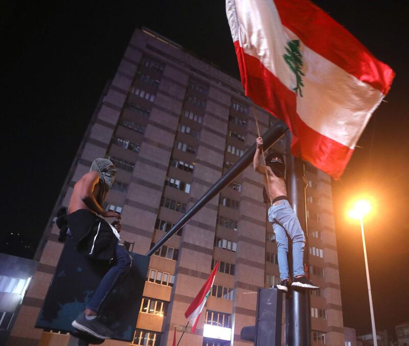 Lebanese anti-government protesters wave their country's flag as they block a main avenue in reaction to the speech of Lebanon's president Michel Aoun in Beirut. AFP