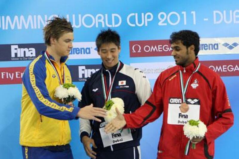 Mohammed Humaid Al Ghafri, of the UAE, right, was thrilled after a third-place finish in the 50m backstroke.