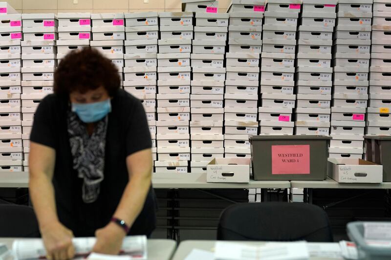 Boxes used to hold mail-in ballots are stacked against the wall as a Board of Election employee prepares mail-in ballots for counting in Linden, New Jersey. AP Photo