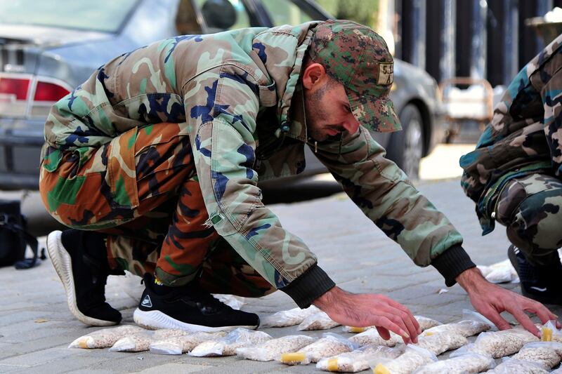 A Syrian officer examines seized Captagon pills. AP