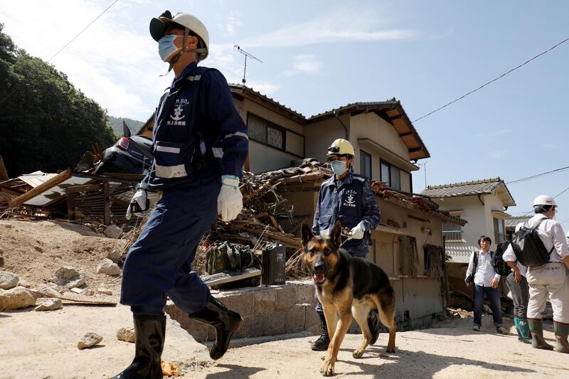 Japan's Maritime Self-Defense Force's personnel search for missing people with a search and rescue dog in Kure, Hiroshima Prefecture, western Japan, on July 12, 2018. EPA