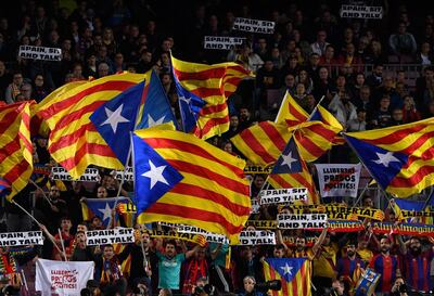 (FILES) In this file photo taken on November 05, 2019 Barcelona's supporters hold placards reading "Spain, sit and talk" and wave Catalan pro-independence "Estelada" flags from the stands during the UEFA Champions League group F football match between FC Barcelona and SK Slavia Prague at the Camp Nou stadium. Some 3,000 police officers and private security agents will be deployed for the rescheduled 'Clasico' against Real Madrid next week, local officials said Friday, amid renewed fears of unrest around the fixture. Protestors from the Catalan separatist movement Democratic Tsunami have called for a "massive" protest outside Camp Nou, where Barcelona are due to play the La Liga match against Real Madrid on December 18. 
 / AFP / Josep LAGO
