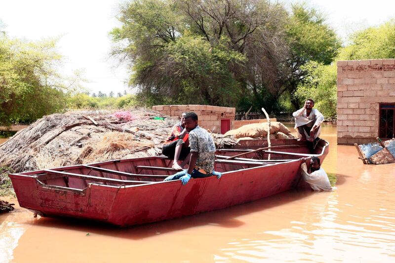 Sudanese men ride a boat through flood water in Wad Ramli village on the eastern banks of the Nile river.  AFP