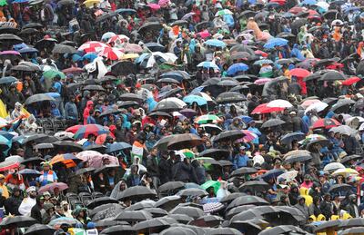 Spectators stand under their umbrellas after rain stopped play during the Cricket World Cup match between India and Pakistan at Old Trafford in Manchester, England, Sunday, June 16, 2019. (AP Photo/Aijaz Rahi)