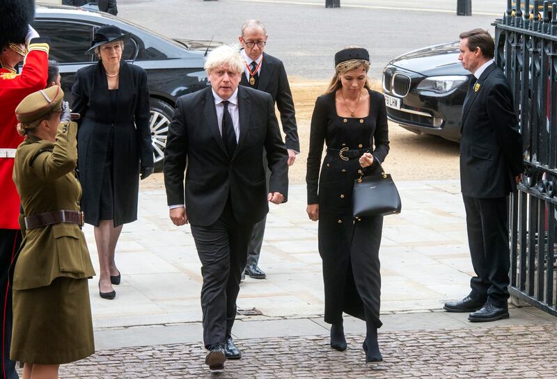 Former British prime minister Boris Johnson and his wife, Carrie Johnson, arrive at the funeral. AP