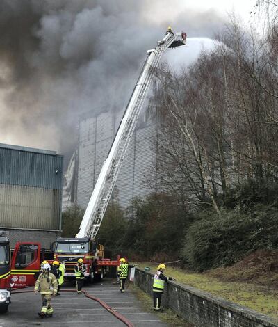 Firefighters at the scene of a fire at the Ocado robotic warehouse in Andover, England, as a huge blaze that swept through the building was brought under control, Wednesday Feb. 6, 2019. (Andrew Matthews/PA via AP)