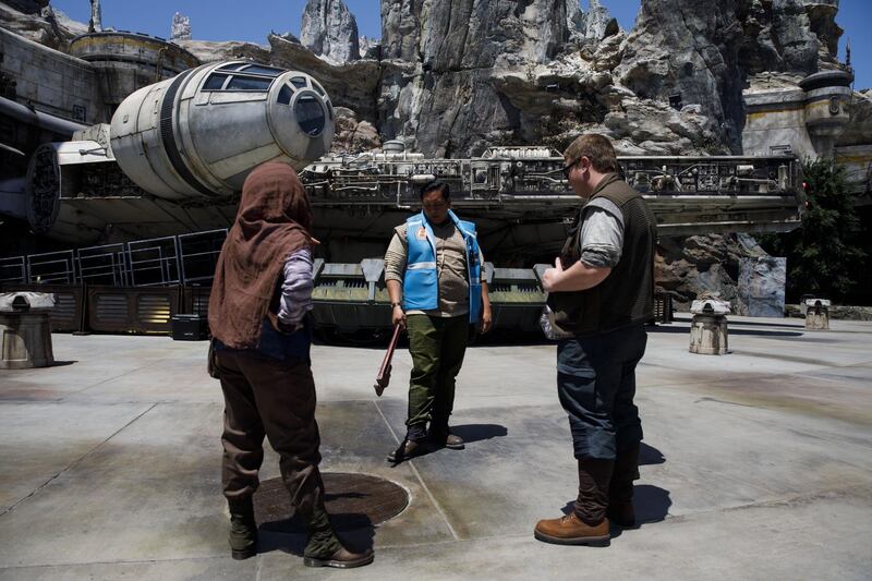 Cast members stand in front of the Millennium Falcon. Bloomberg