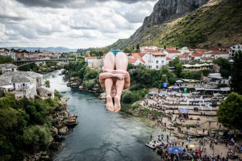 MOSTAR, BOSNIA AND HERZEGOVINA  - AUGUST 27: (EDITORIAL USE ONLY) In this handout image provided by Red Bull, Steven LoBue of the USA dives from the 27 metre platform on Stari Most (Old Bridge) during the second competition day of the third stop of the Red Bull Cliff Diving World Series on August 27, 2021 at Mostar, Bosnia and Herzegovina. (Photo by Romina Amato / Red Bull via Getty Images)