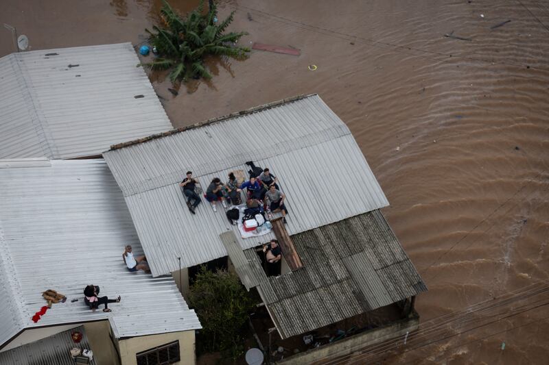 People wait to be rescued by a Brazilian Army helicopter during an operation to rescue people trapped in their homes due to a flood, in Canoas. EPA