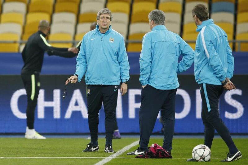 Manchester City manager Manuel Pellegrini talks to assistant managers Ruben Cousillas (R) and Brian Kidd during training. Action Images via Reuters / John Sibley