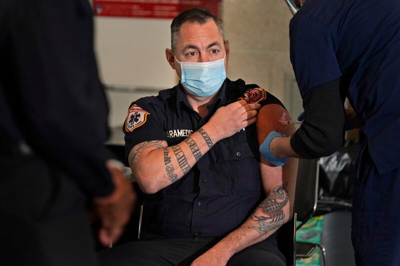 A New York City firefighter paramedic receives a Covid-19 vaccination at the FDNY Fire Academy in New York. AP