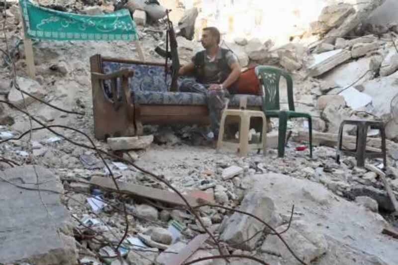 A Free Syrian Army fighter sits on a sofa along a street in Aleppo's Salaheddine neighbourhood. Nearby Khan Al Assal, the scene of a purported chemical attack, had been taken by the rebels last week.