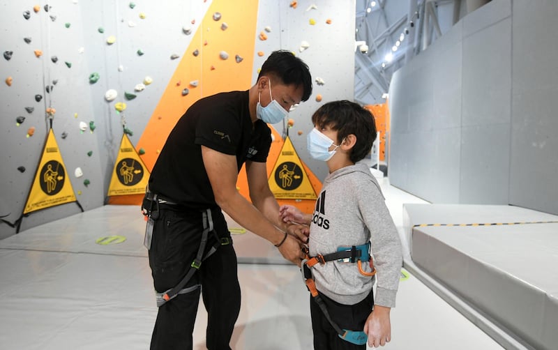 Abu Dhabi, United Arab Emirates - Mazen, 7, having his harness tied on for the indoor climbing at CLYMB, Yas Island. Khushnum Bhandari for The National